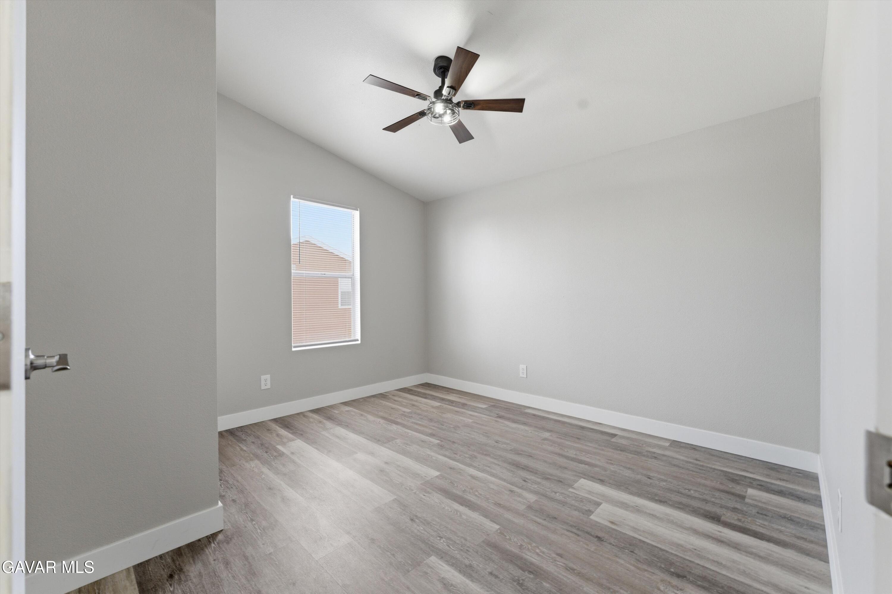 20843 Waalew Road Apple Valley, CA 92307 - Photo 16 of 40 an empty room with wooden floor and windows