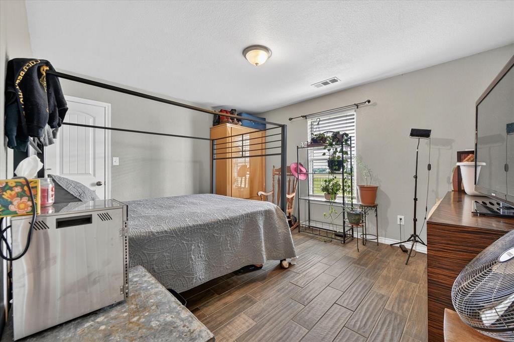 7145 Donald Road Krum, TX 76249 - Photo 22 of 35 a bedroom with a bed and a mirror