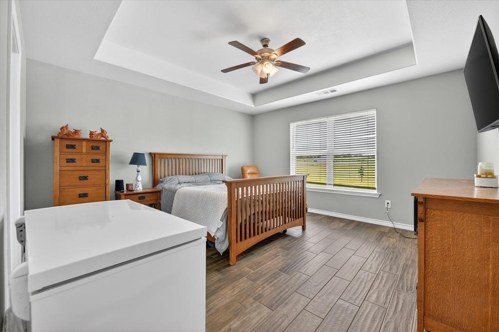 7145 Donald Road Krum, TX 76249 - Photo 23 of 35 a bedroom with a bed and a chandelier