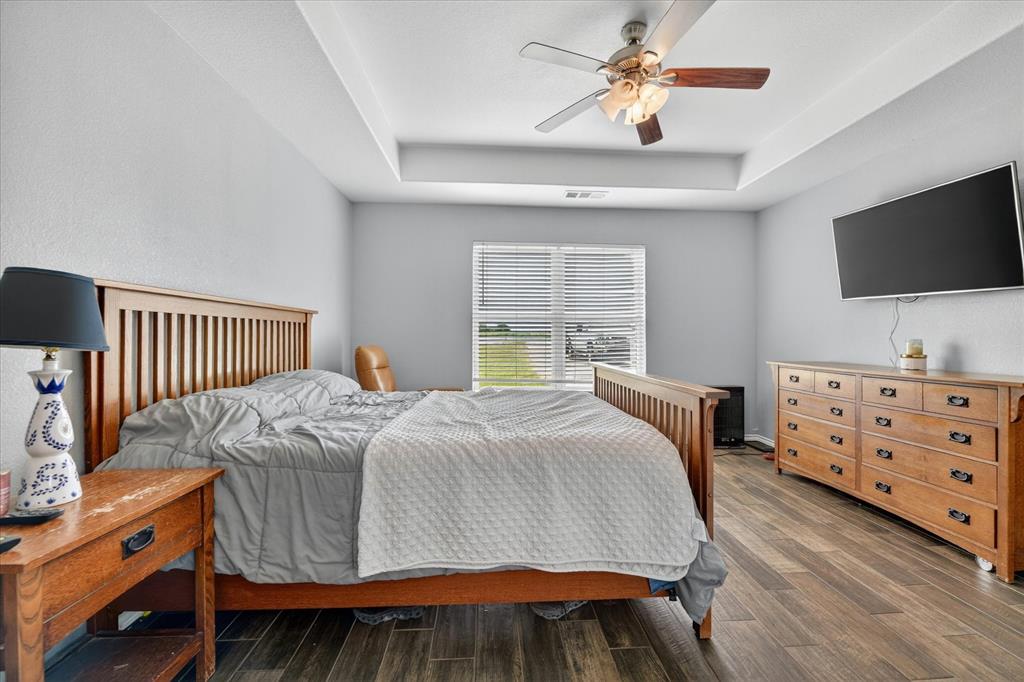 7145 Donald Road Krum, TX 76249 - Photo 26 of 35 a bedroom with a bed and a flat screen tv