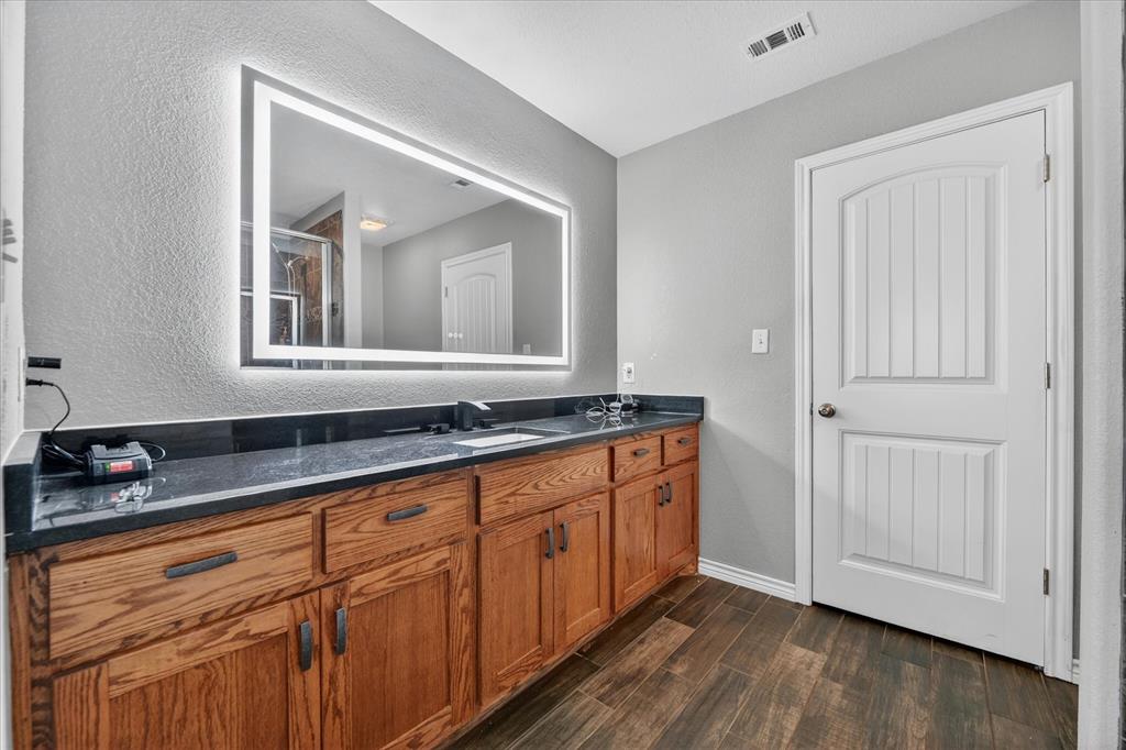 7145 Donald Road Krum, TX 76249 - Photo 27 of 35 a hallway with granite countertop white cabinets and wooden floor
