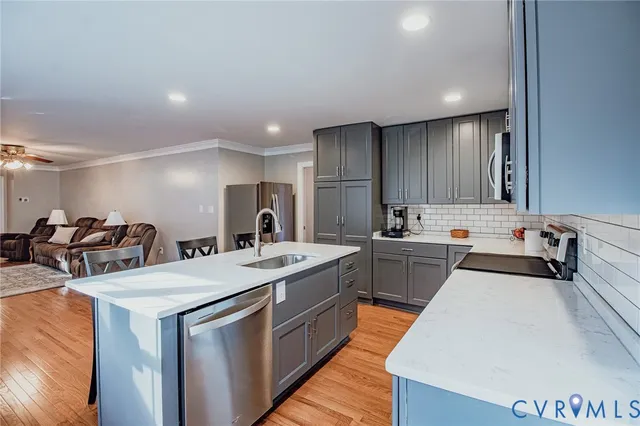 a large kitchen with stainless steel appliances a sink a stove and a refrigerator