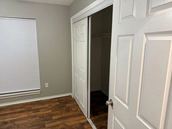 a view of a hallway with wooden floor and closet