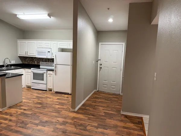a kitchen with cabinets and wooden floor