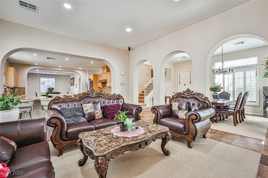 7643 Cascade Ridge Court Las Vegas, NV 89113 - Photo 11 of 46 Living area with arched walkways, a chandelier, recessed lighting, healthy amount of natural light, and stairway