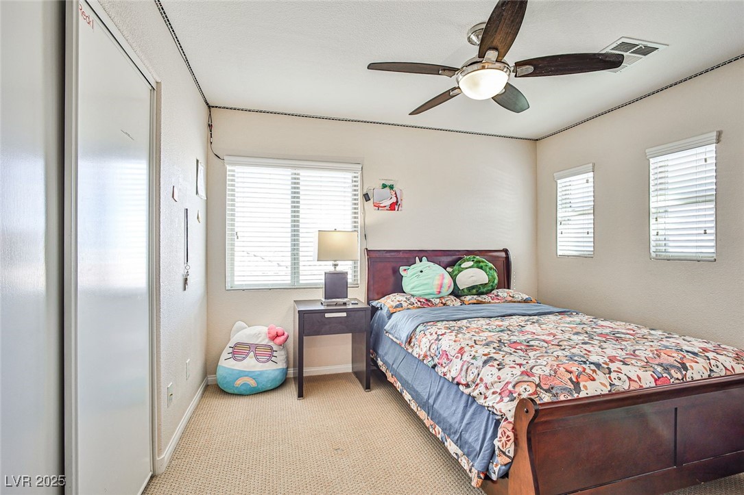 7643 Cascade Ridge Court Las Vegas, NV 89113 - Photo 39 of 46 Bedroom featuring light carpet, ceiling fan, and a closet