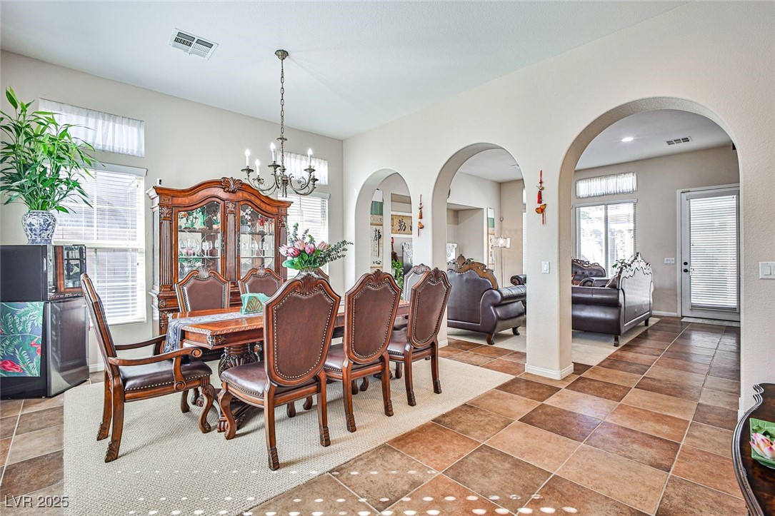 7643 Cascade Ridge Court Las Vegas, NV 89113 - Photo 6 of 46 Dining area with a chandelier and arched walkways