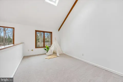 a view of a house with a yard and large tree