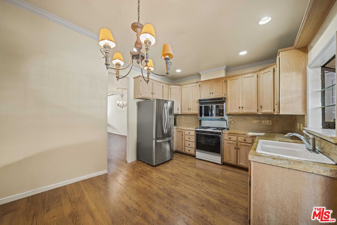 5400 Simpson Avenue, Unit 9 Valley Village, CA 91607 - Photo 11 of 30 a kitchen with stainless steel appliances granite countertop a refrigerator a stove top oven a sink dishwasher and wooden floor