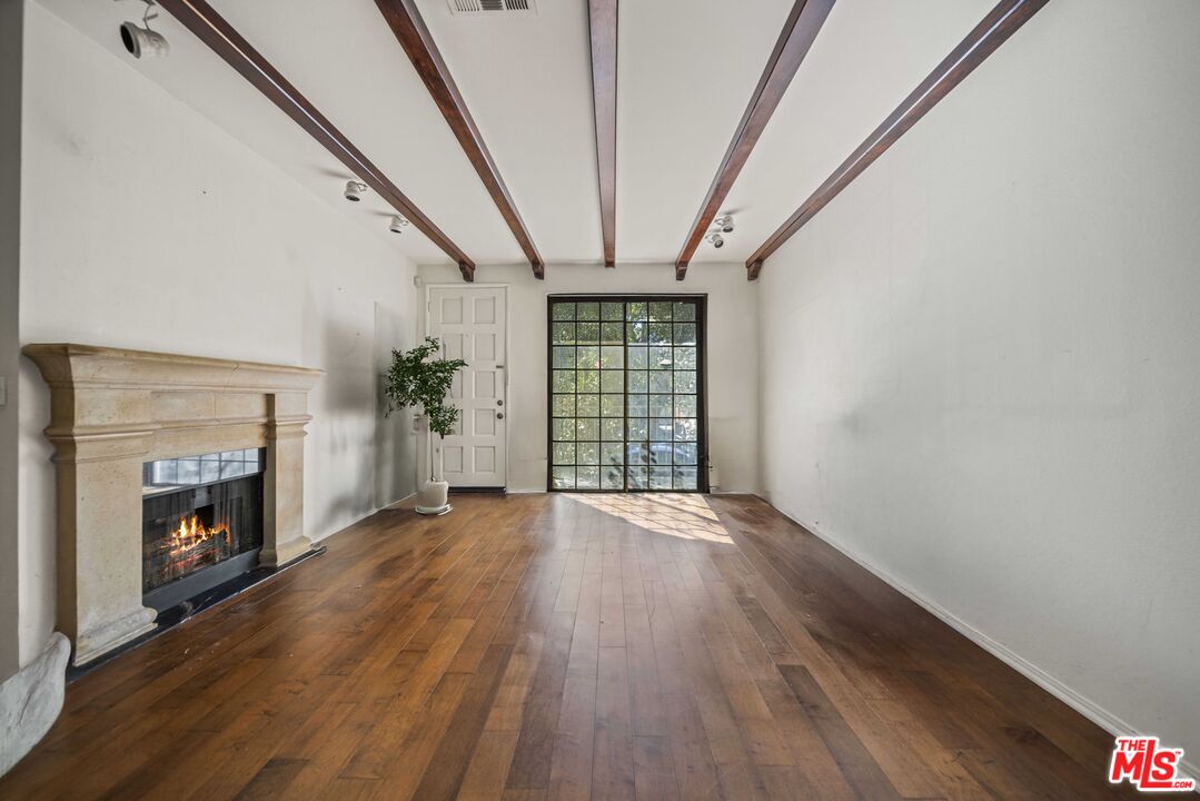 5400 Simpson Avenue, Unit 9 Valley Village, CA 91607 - Photo 5 of 30 a view of an empty room with wooden floor fireplace and a window