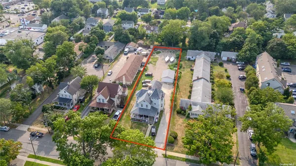 an aerial view of residential house with outdoor space and trees all around