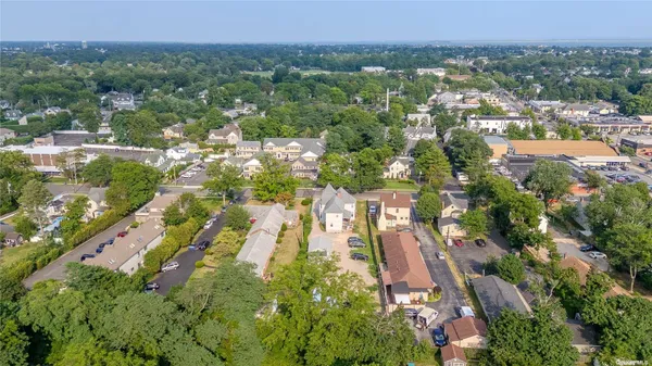an aerial view of residential houses with outdoor space and trees