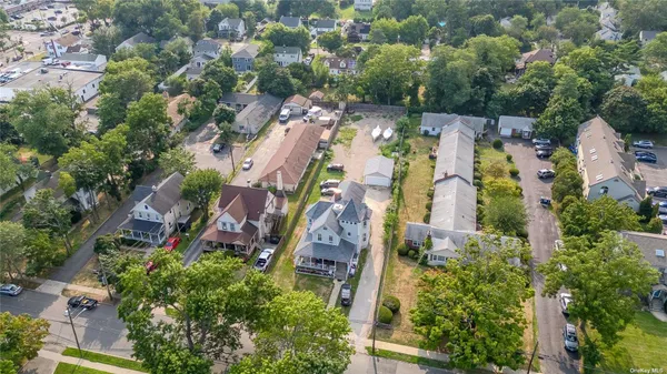 an aerial view of residential houses with outdoor space and trees