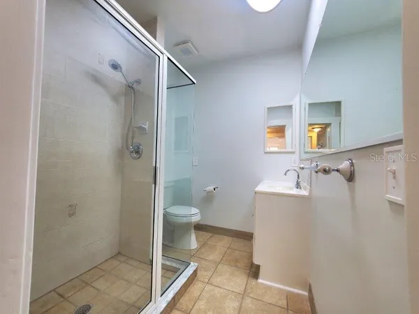 a bathroom with a glass shower door and a glass door