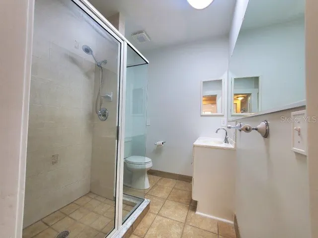 a bathroom with a glass shower door and a glass door