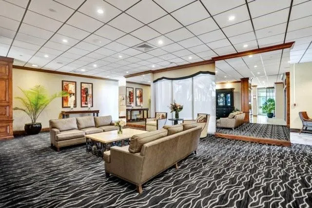 a living room with furniture a large window and a chandelier