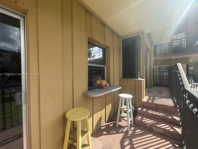 a balcony with two chairs and a table