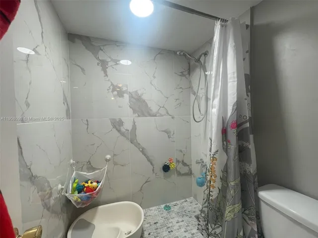 a bathroom with a toilet and shower