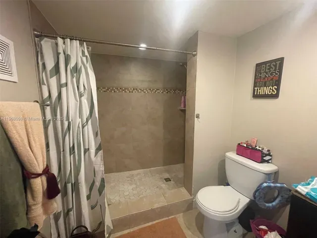 a white toilet sitting next to a shower curtain