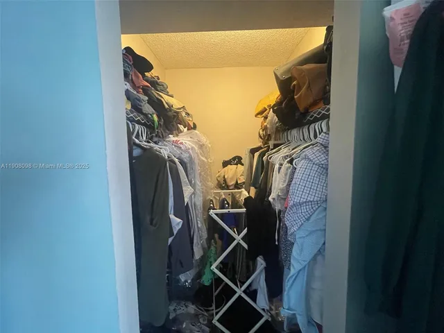 a view of walk in closet with clothes