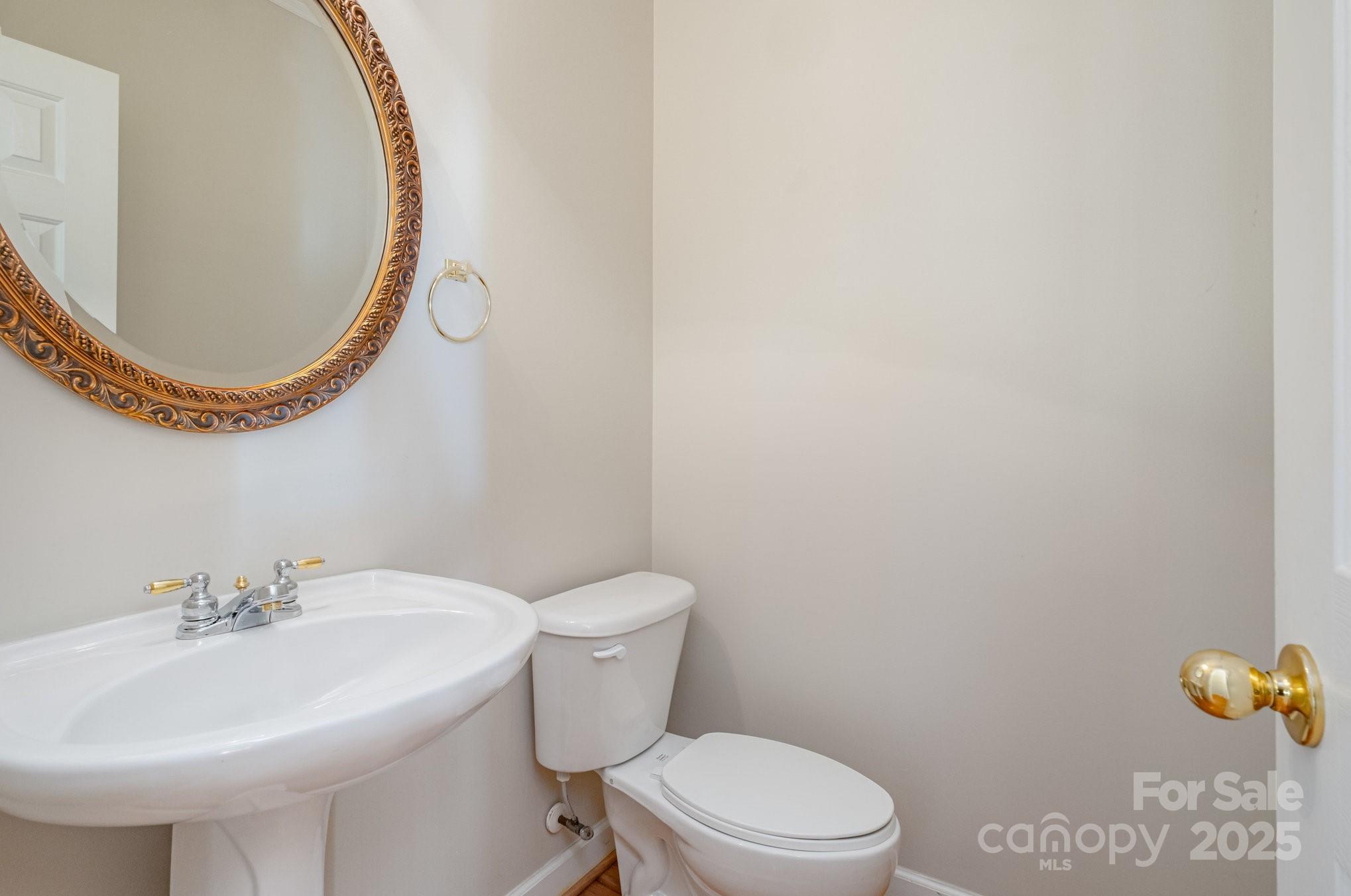1930 Copperplate Road Charlotte, NC 28262 - Photo 21 of 43 a bathroom with a sink a toilet and a mirror