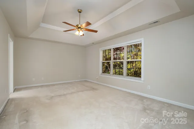 an empty room with a window and a fan