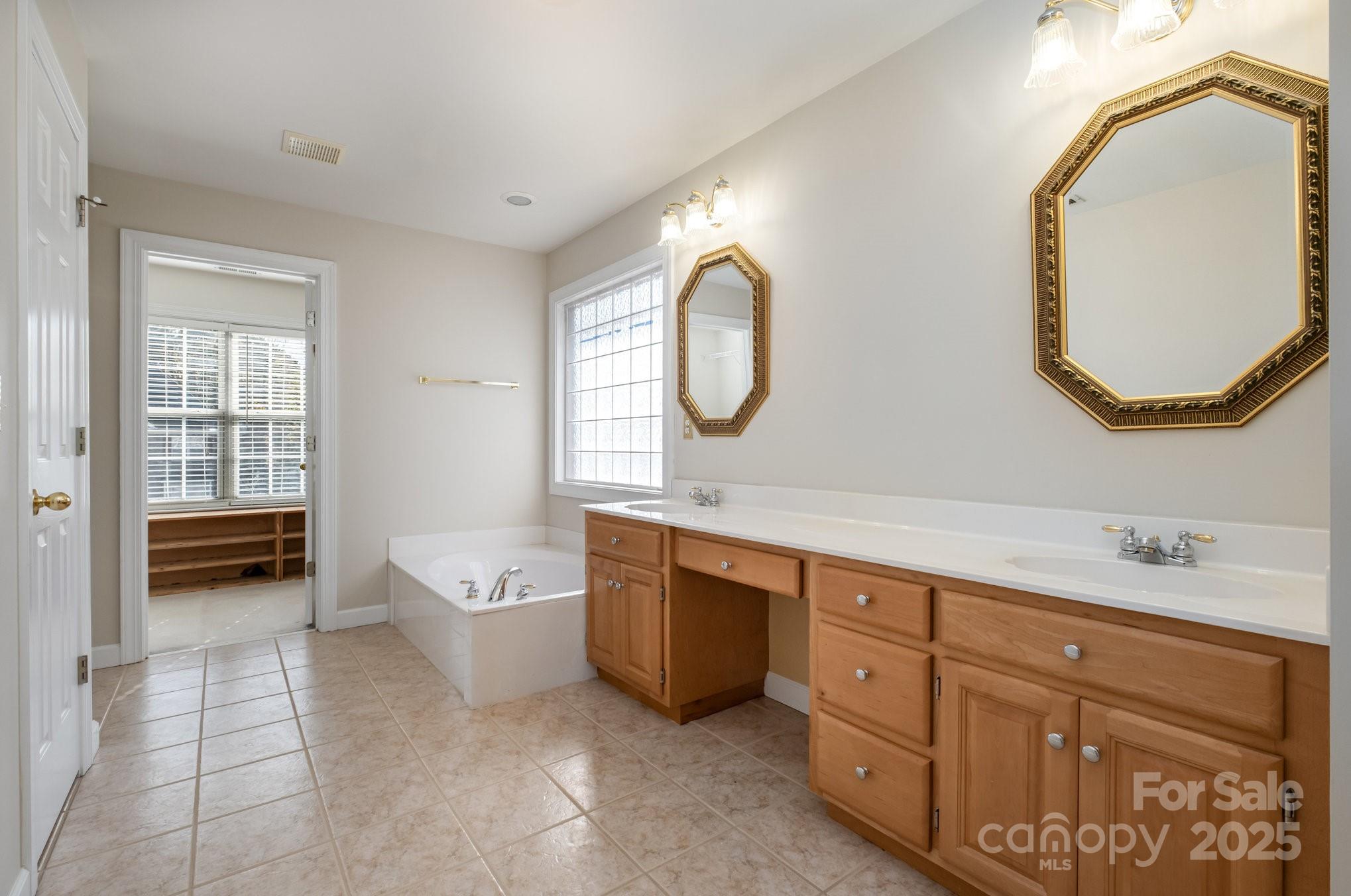 1930 Copperplate Road Charlotte, NC 28262 - Photo 25 of 43 a spacious bathroom with a double vanity sink a mirror and a bathtub