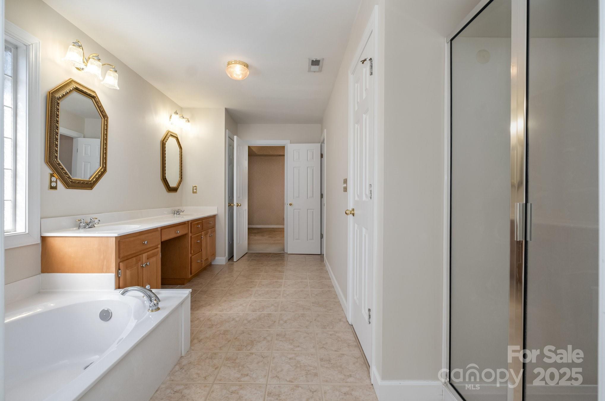 1930 Copperplate Road Charlotte, NC 28262 - Photo 26 of 43 a spacious bathroom with a tub a double vanity sink and mirror