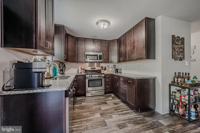 a kitchen with stainless steel appliances granite countertop a stove refrigerator and a sink