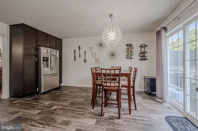 a dining room with furniture a chandelier and wooden floor