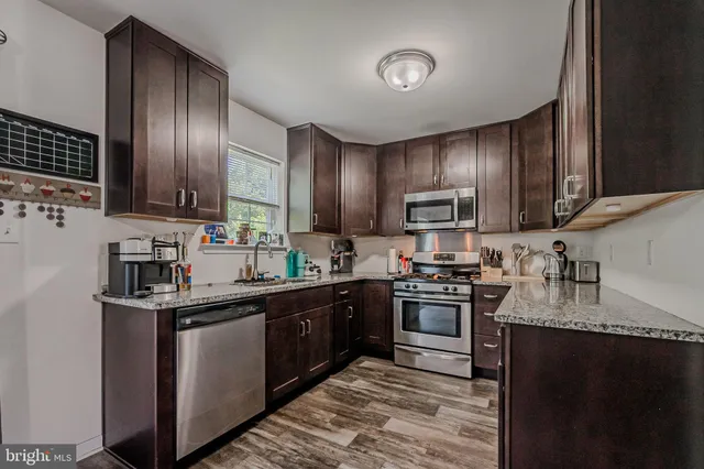 a kitchen with granite countertop stainless steel appliances and sink