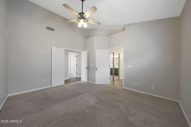 a view of an empty room with a chandelier fan