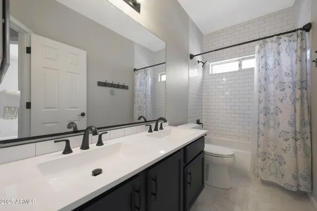 a bathroom with a double vanity sink toilet and a mirror