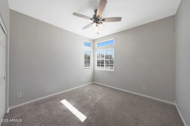 an empty room with a ceiling fan and a window