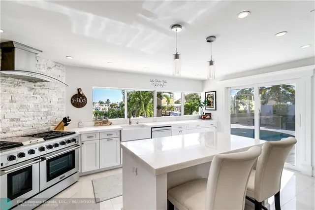 a kitchen with stainless steel appliances granite countertop a sink a stove and a refrigerator