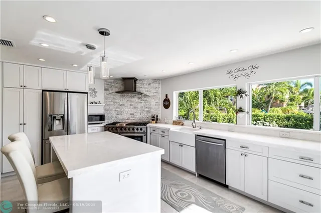 a kitchen that has a sink a stove and a refrigerator