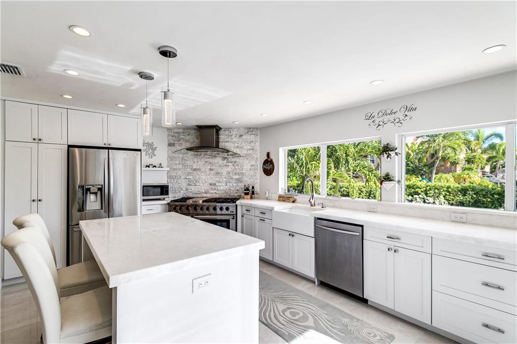 2948 Northeast 35th Court Lighthouse Point, FL 33064 - Photo 12 of 24 a kitchen that has a sink a stove and a refrigerator