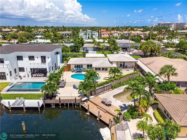 a view of a swimming pool with lawn chairs and potted plants