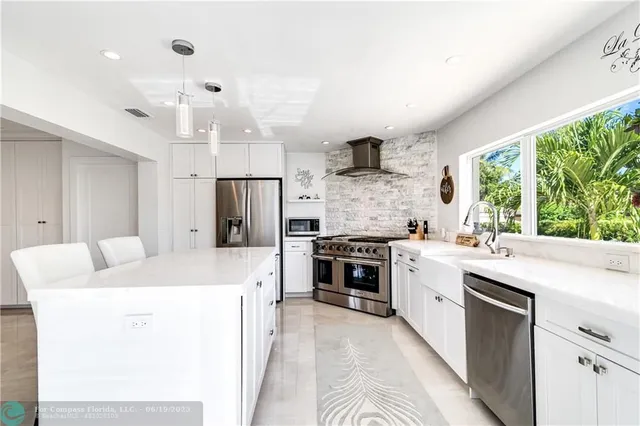 a large kitchen with kitchen island a stove a sink and a refrigerator