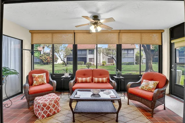 a living room with furniture and a floor to ceiling window
