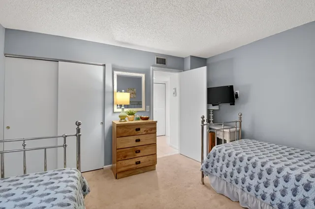 a bedroom with a bed and a flat tv screen on dresser