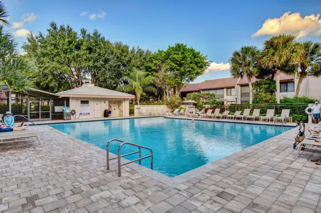 a view of house with swimming pool and sitting area