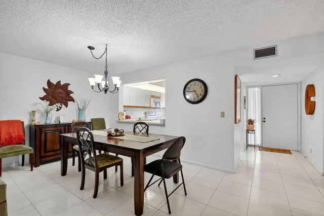 a view of a dining room with furniture and chandelier
