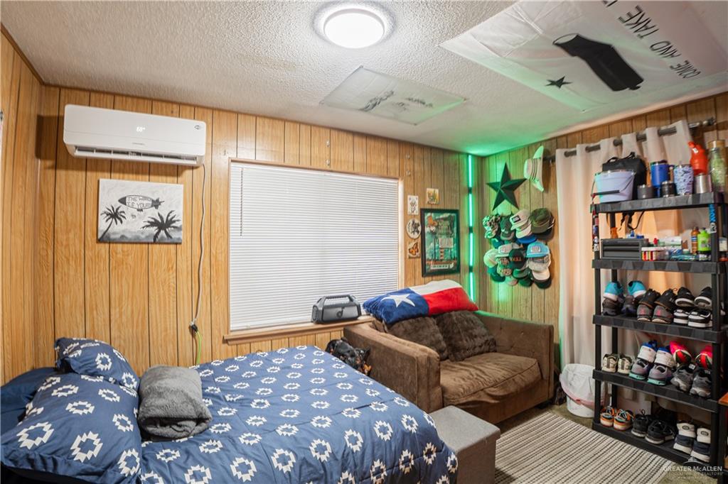 425 South Reynolds Rio Hondo, TX 78583 - Photo 17 of 23 This room features wood paneling, a window with blinds, and a wall-mounted air conditioning unit