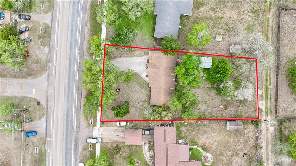 425 South Reynolds Rio Hondo, TX 78583 - Photo 22 of 23 Aerial view of the property, featuring a main residence with a brown roof, surrounded by mature trees and a large, grassy yard