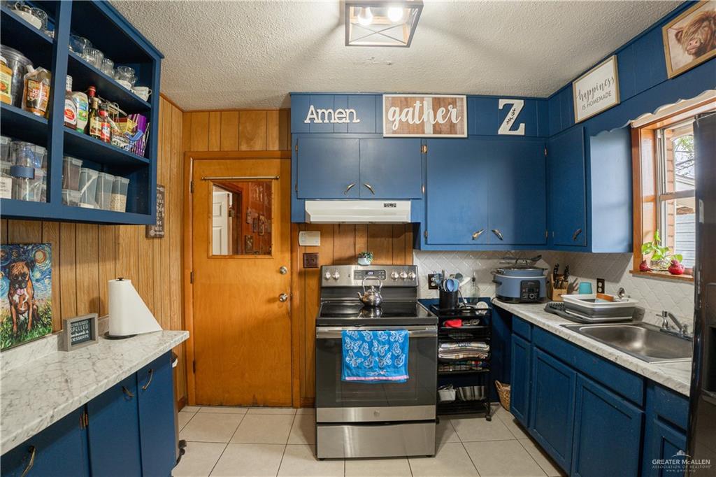 425 South Reynolds Rio Hondo, TX 78583 - Photo 8 of 23 The kitchen features blue cabinetry with a white countertop and a stainless steel oven