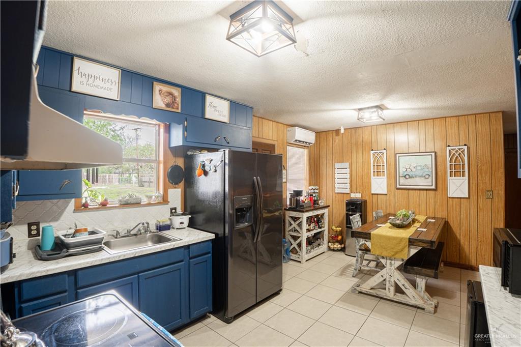 425 South Reynolds Rio Hondo, TX 78583 - Photo 9 of 23 The kitchen features blue cabinetry, a stainless steel sink, and a large window providing natural light