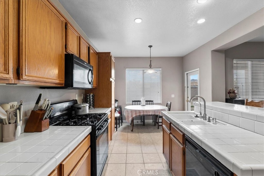 1474 Albillo Loop Perris, CA 92571 - Photo 12 of 35 a kitchen with stainless steel appliances granite countertop a sink stove and cabinets