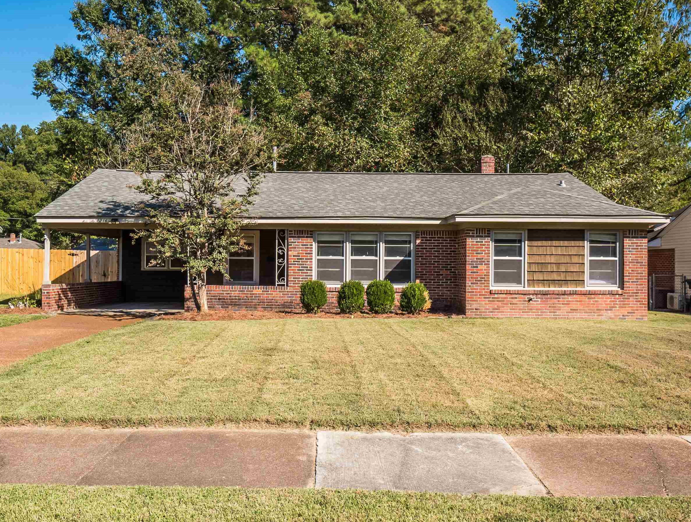 1216 West Perkins Road Memphis, TN 38117 - Photo 1 of 30 a front view of a house with a yard and garage