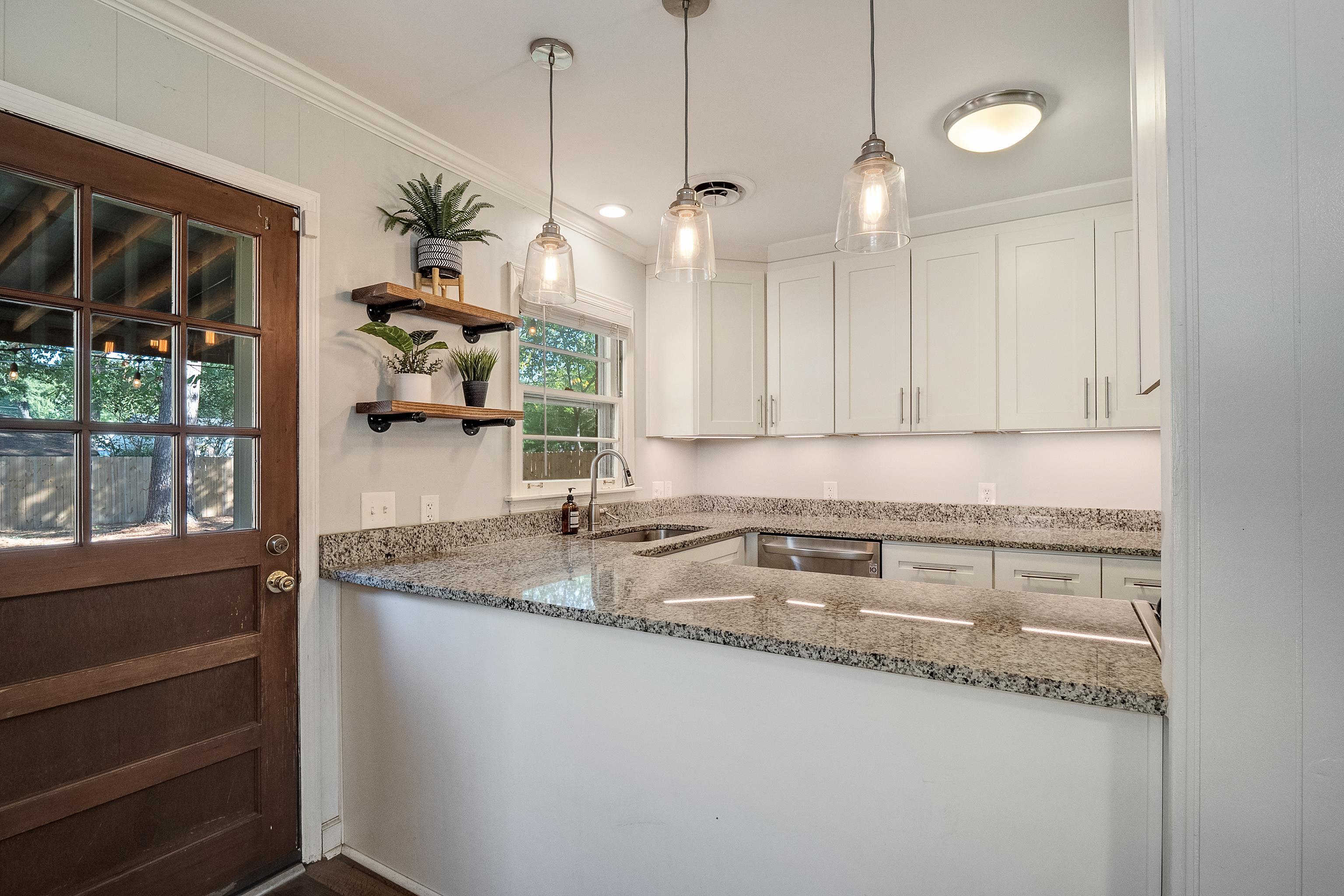 1216 West Perkins Road Memphis, TN 38117 - Photo 13 of 30 a kitchen with stainless steel appliances granite countertop a sink a window and a counter top space